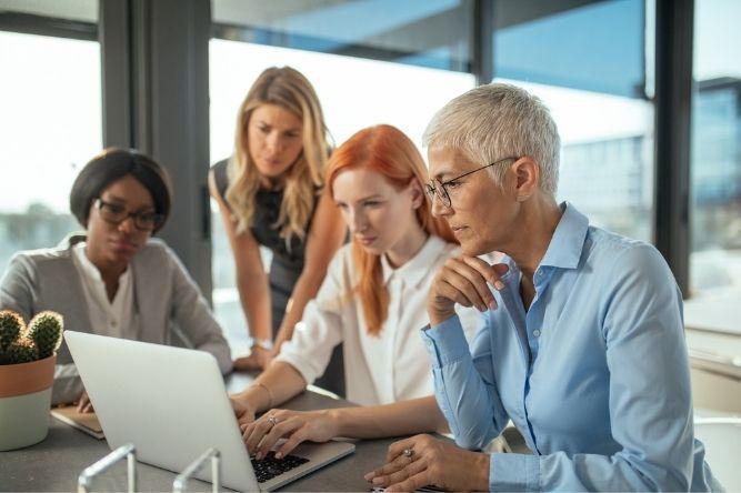 Group of female businesswomen working together on a laptop